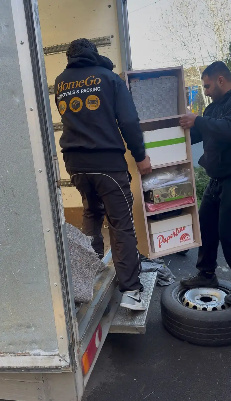 HomeGo crew member in branded hoodie loading shelving — professional packing services Slough